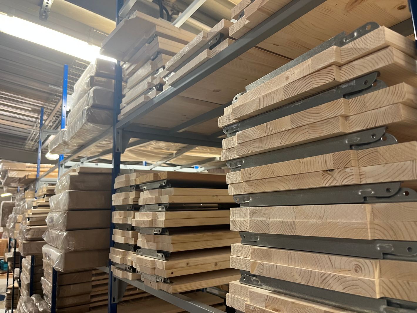 Les tablettes en bois d'épicéa pour l'étagère brumorek sur une étagère en métal dans un entrepôt 